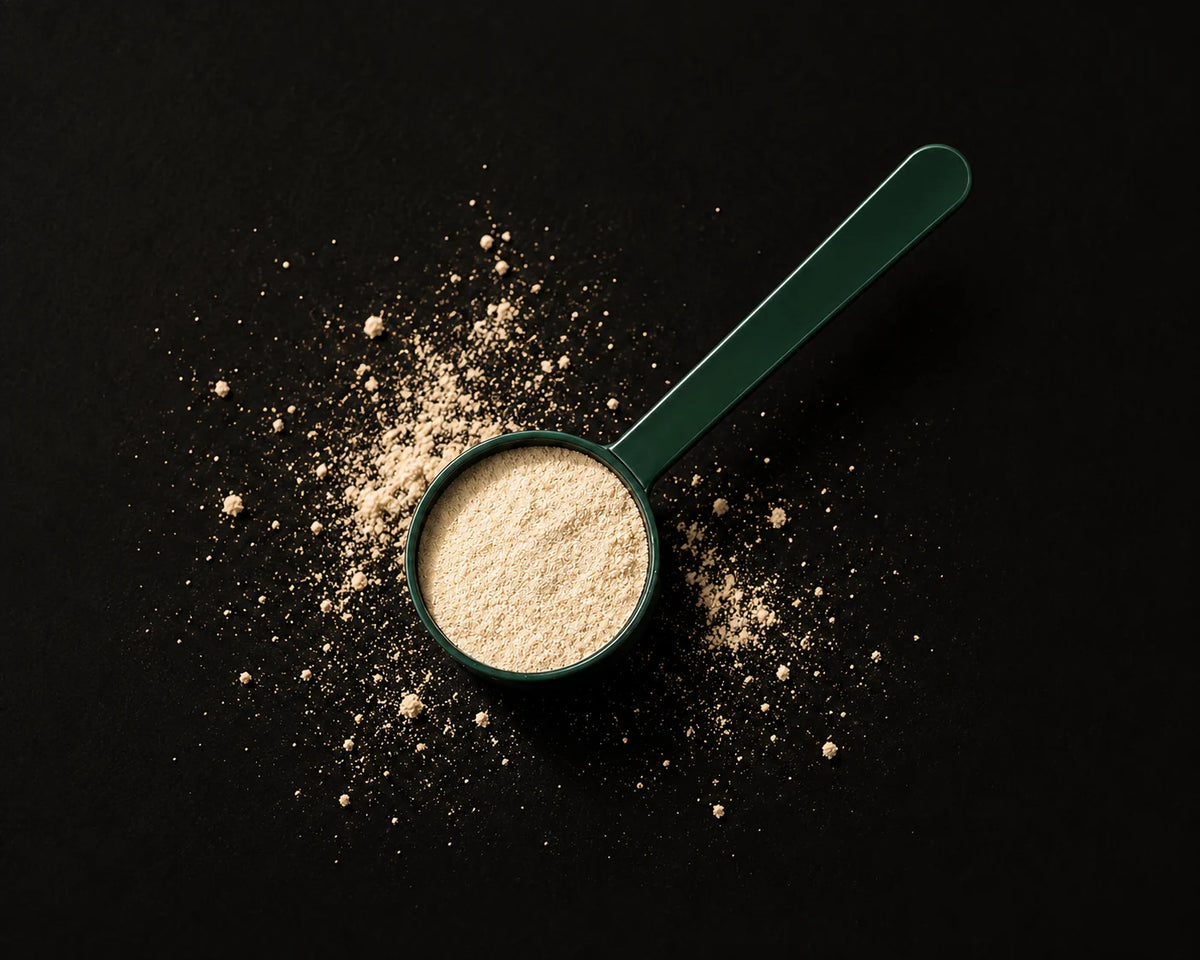 Small green measuring scoop with a modest portion of powder and its full handle visible