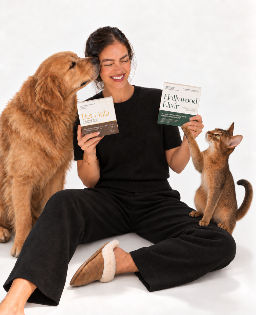 A smiling woman holding Pet Gala and Hollywood Elixir, a golden retriever nuzzling her cheek and a cat reaching up